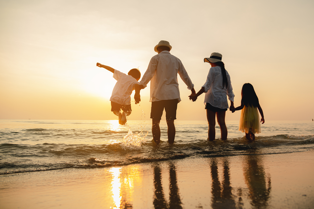 family on the ebach at sunset